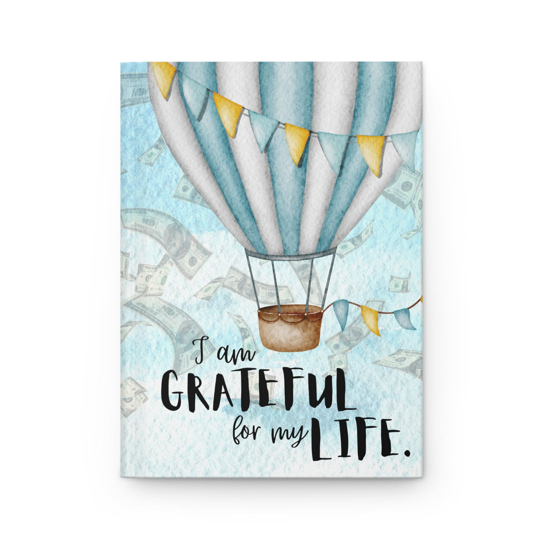 white and blue balloon on sky like background with money falling. Says "i am grateful for my life"